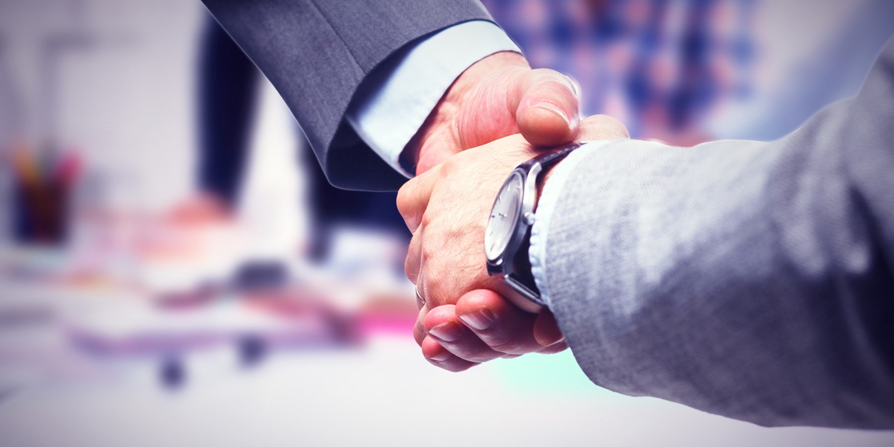 close up image of two business men shaking hands after forming a partnership