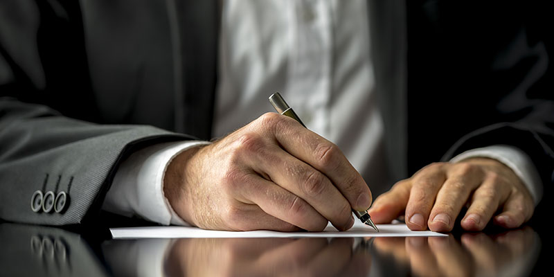 close up of a business man signing a document